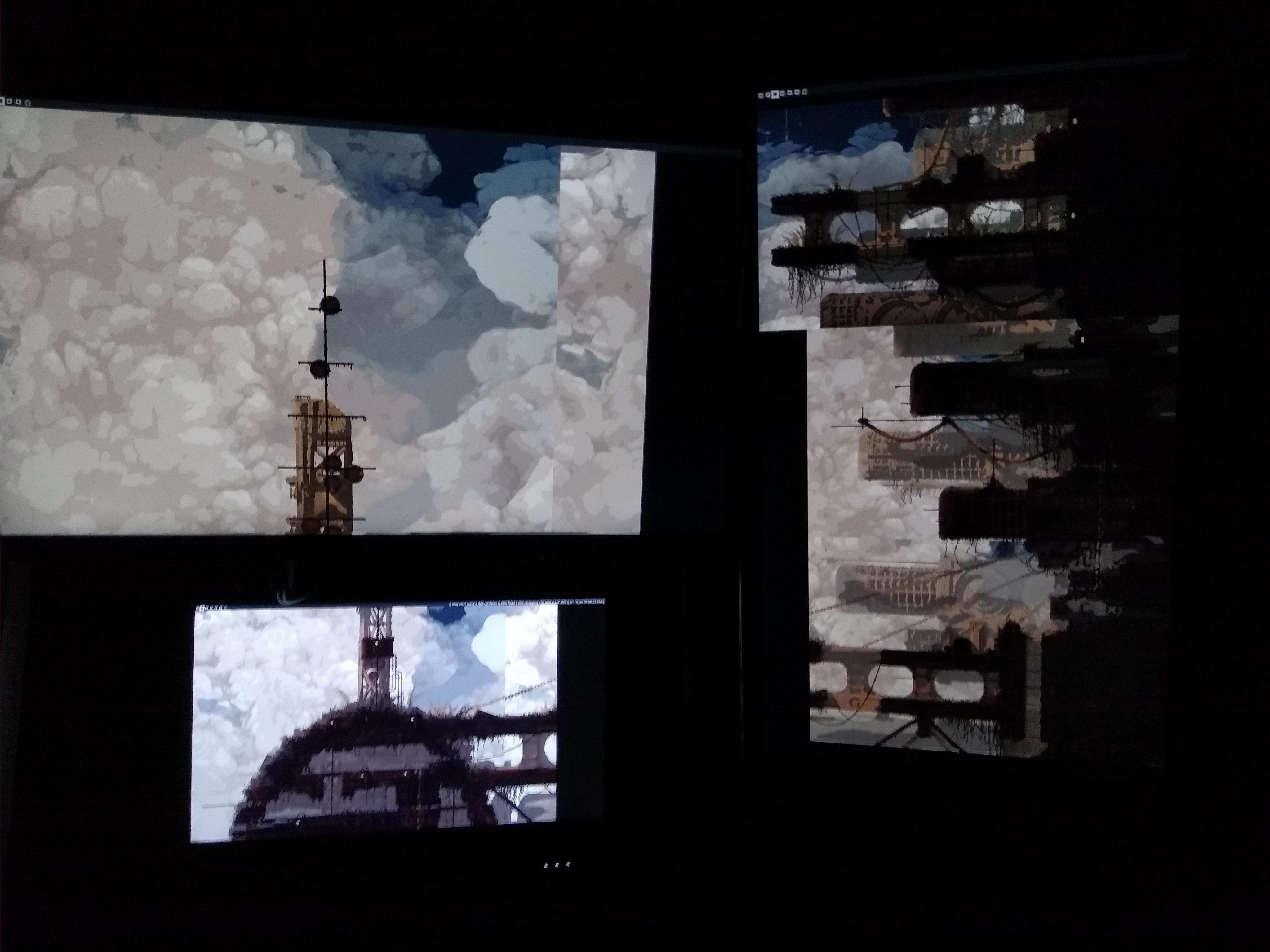 A picture of a computer setup. There are multiple monitors each only displaying a wallpaper, which is stretched across all of the monitors.